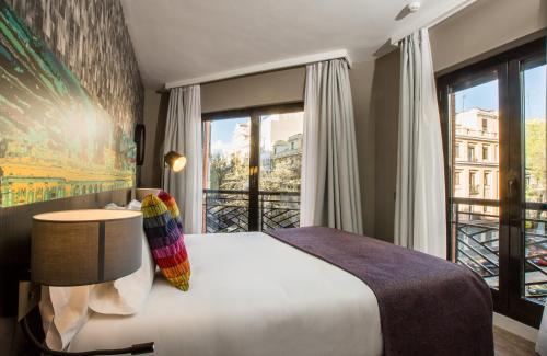 Leonardo Boutique Hotel Madrid في مدريد: غرفة نوم بسرير ونافذة كبيرة