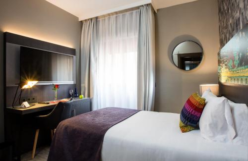 a hotel room with a bed and a desk and a mirror at Leonardo Boutique Hotel Madrid in Madrid