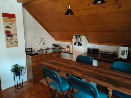een keuken met een houten aanrecht en blauwe stoelen bij Vila Jezerski raj in Bor