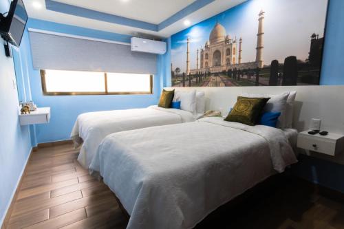 two beds in a room with blue walls at Hotel Boutique Mardeka in Orizaba