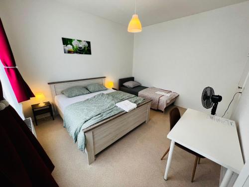 a bedroom with a bed and a desk and a table at Ganha holiday house in Antwerp