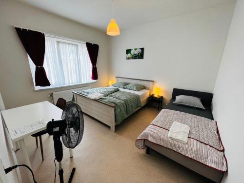 a bedroom with two beds and a fan in it at Ganha holiday house in Antwerp