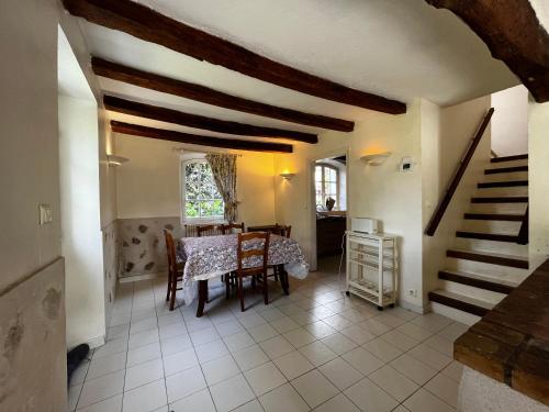 cocina y comedor con mesa y escaleras en Gites aux Fleurs de Cerises, en Le Plessis-Luzarches