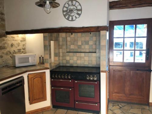 a kitchen with a stove top oven next to a door at le Pargagnat in Préchac
