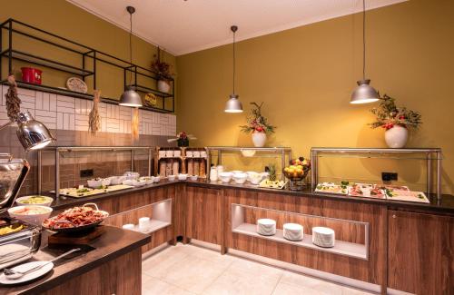 a restaurant kitchen with a buffet of food at Leonardo Hotel Bad Kreuznach in Bad Kreuznach