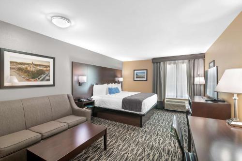 a hotel room with a bed and a couch at Best Western Plus Denton Inn & Suites in Denton