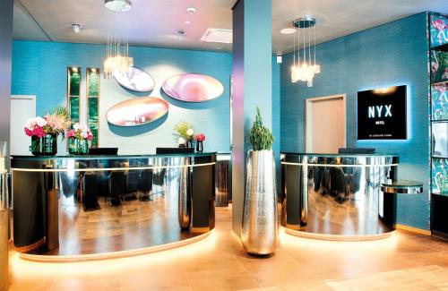 a lobby with a hair salon with two mirrors at NYX Hotel Munich by Leonardo Hotels in Munich