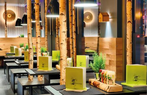 a restaurant with tables and trees in the background at NYX Hotel Munich by Leonardo Hotels in Munich