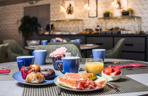 a table topped with plates of breakfast foods and orange juice at Leonardo Hotel Barcelona Gran Via in Barcelona