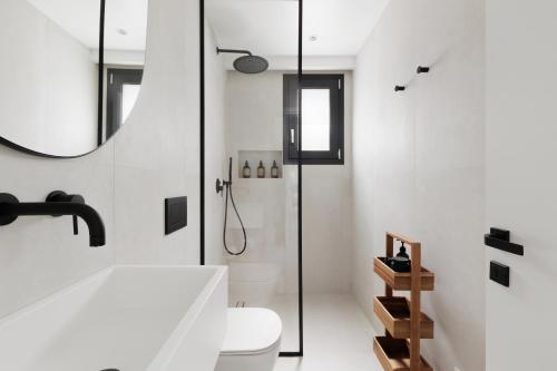 a bathroom with a shower and a toilet and a sink at Luxurious Villa Trinity in Kontokali