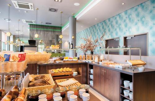 a restaurant with a buffet line with food on display at Leonardo Royal Hotel Ulm in Ulm