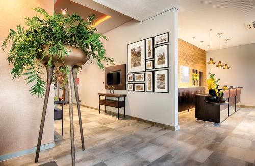 a room with a large potted plant in the middle at Leonardo Royal Hotel Ulm in Ulm