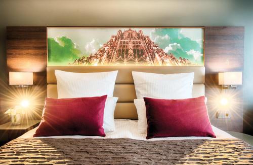 a bedroom with a large painting above a bed at Leonardo Royal Hotel Ulm in Ulm