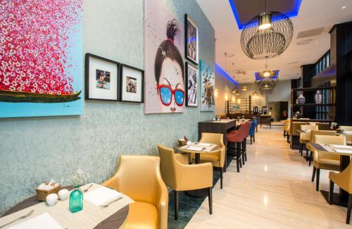 a dining room with tables and chairs in a restaurant at Leonardo Hotel Madrid City Center in Madrid
