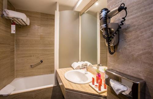 a bathroom with a sink and a shower and a tub at Leonardo Hotel Madrid City Center in Madrid