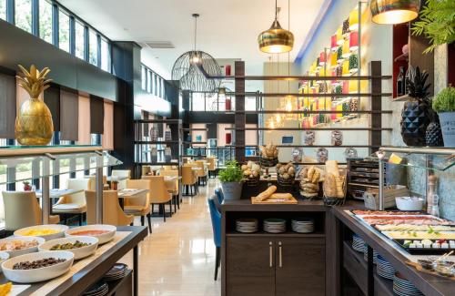 un restaurante con mesas, sillas y comida a la vista en Leonardo Hotel Madrid City Center en Madrid