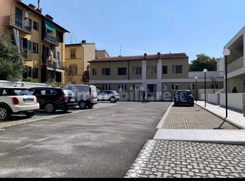 une rue de la ville avec des voitures garées dans un parking dans l'établissement Appartamento Careggi con posto auto, à Florence