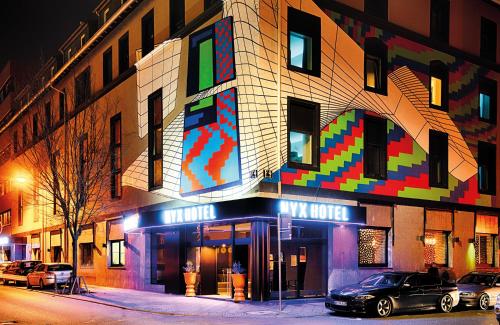 a building with a multicolored sign on the side of it at NYX Hotel Mannheim by Leonardo Hotels in Mannheim