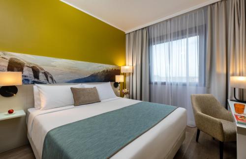 A bed or beds in a room at Leonardo Hotel Verona