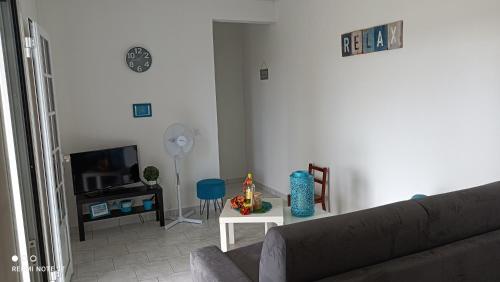 sala de estar con sofá y TV en T2 jardin clos Les Nids de la Colline en Saint-François
