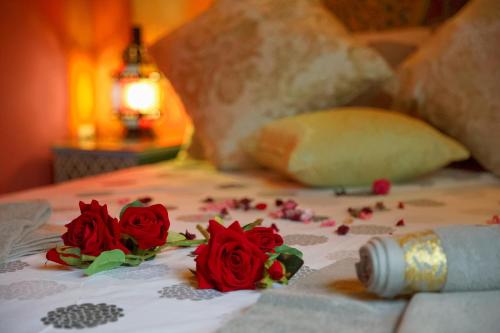 a group of red roses on a bed at Riad Dar Kassim in Fès