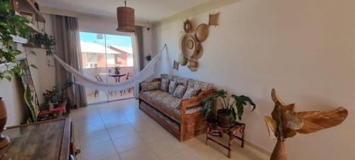 a living room with a couch and a window at Apartamento à beira-mar: ideal para famílias . in Ilhéus