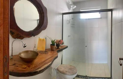 uma casa de banho com um lavatório e um chuveiro com um espelho. em Apartamento à beira-mar: ideal para famílias . em Ilhéus