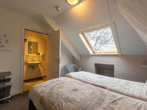 1 dormitorio en el ático con 2 camas y ventana en Lodge Slabroek, en Uden