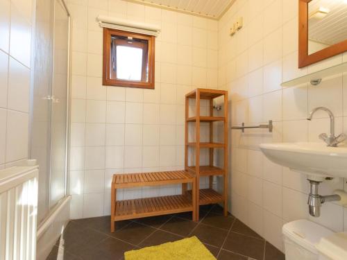 a bathroom with a sink and a toilet and a shelf at Witte Bungalow in Uden