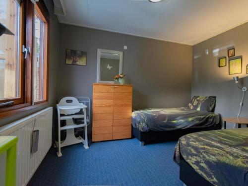 a room with two beds and a dresser and a bedroom at Witte Bungalow in Uden