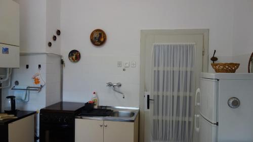 a kitchen with a sink and a white refrigerator at Apartment Mia in Donja Pačetina