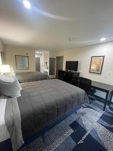 een slaapkamer met een bed en een bureau met een computer bij Fairway Inn in Iowa