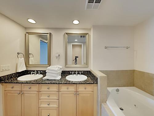 y baño con 2 lavabos y bañera. en Portofino Island Resort 3-1209, en Pensacola Beach
