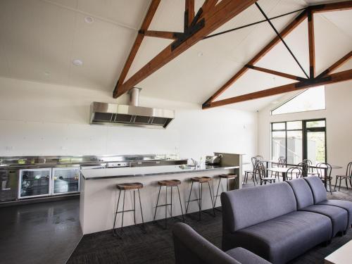 uma cozinha em plano aberto e sala de estar com sofá e bar em Wanaka Top 10 Holiday Park em Wanaka