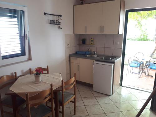 eine Küche mit einem Tisch und einem Waschbecken sowie einem Tisch und Stühlen in der Unterkunft Apartments by the sea Zaostrog, Makarska - 6659 in Zaostrog