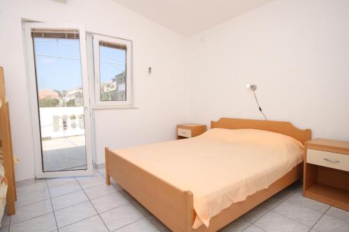 een slaapkamer met een bed en een groot raam bij Apartments by the sea Metajna, Pag - 6336 in Metajna