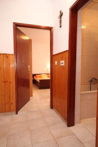 a hallway with a door and a room with a bed at Apartments by the sea Metajna, Pag - 6336 in Metajna