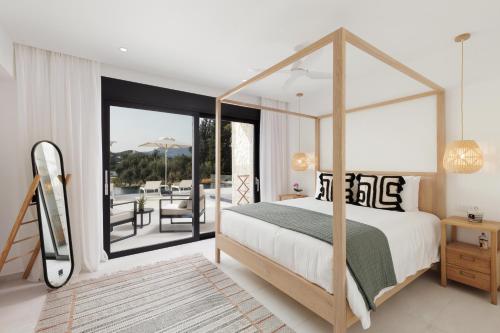 - une chambre avec un lit à baldaquin et une terrasse dans l'établissement Luxurious Villa Trinity, à Kontokali