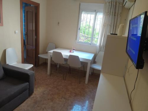 バレンシアにあるApartamento Alguerのリビングルーム(白いテーブル、椅子、テレビ付)