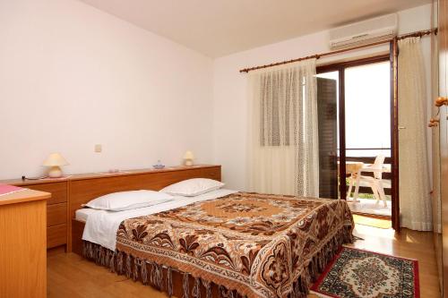 a bedroom with a bed and a large window at Apartments and rooms with parking space Icici, Opatija - 7881 in Ičići