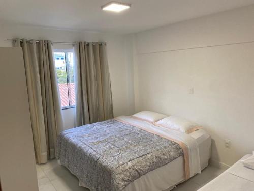 Habitación blanca con cama y ventana en Apartamento com piscina Condomínio Balneário Camboriú, en Balneário Camboriú