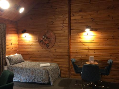 a bedroom with a bed and a table and chairs at Alpine Lodge Motel in Hanmer Springs