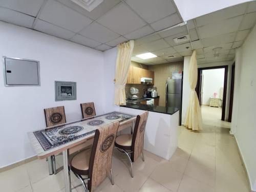 a kitchen with a table and chairs in a room at Cheap Holiday Home in Ajman 