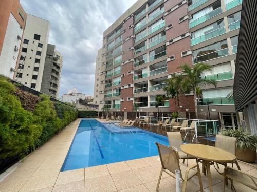 a swimming pool on a balcony with a table and chairs at Lindo Studio no coracao da Vila Madalena in Sao Paulo