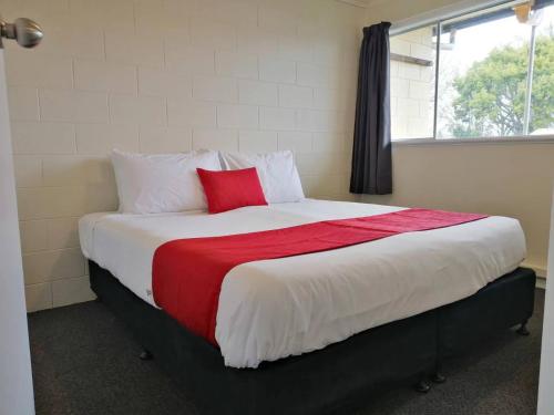 a bedroom with a large bed with a red pillow at Stanley Apartments in Hamilton