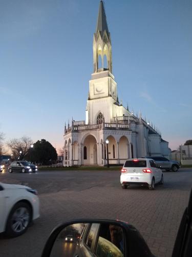 Una iglesia con coches aparcados delante de ella. en Antonia, en Villa Elisa