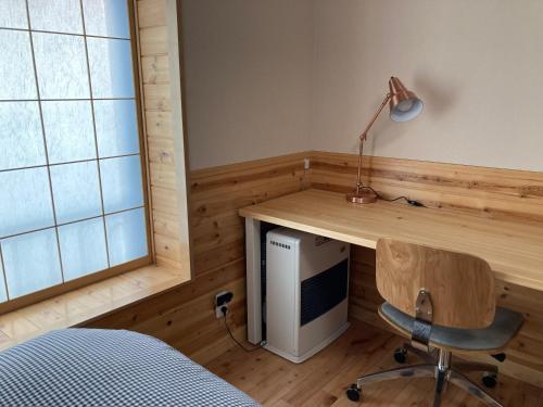 a bedroom with a desk and a chair and a computer at Marushige in Nozawa Onsen