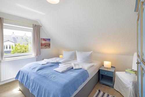 een slaapkamer met een bed met blauwe lakens en een raam bij Captains Home in List