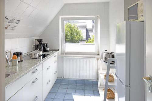 a kitchen with white cabinets and a refrigerator at Captains Home in List