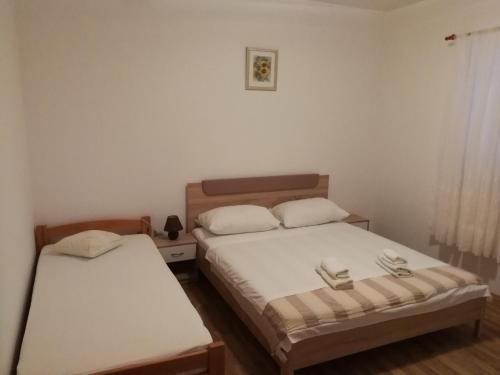 2 Betten in einem kleinen Zimmer mit weißen Wänden in der Unterkunft Apartments by the sea Cove Ostricka luka, Rogoznica - 13709 in Rogoznica